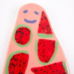 Ceramic flat sculpture of a pink ghost with cut watermelon all over it