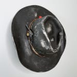 Brock DeBoer sculpture of a black cowboy hat with gold playing cards and bullet on the brim