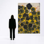 Jorge Luis Santos painting with black and yellow spots with woman standing next to it
