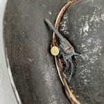 Brock DeBoer sculpture of a black cowboy hat with gold playing cards and bullet on the brim