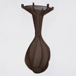 A dark brown, translucent fabric vessel floats in midair