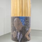 Round freestanding wood sculpture with an image of a male figure adhered to the surface and obscured by thousands of clear push pins