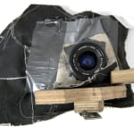Sculpture created from canvas, camera lens, digital camera parts, duct tape, fabric, gesso, graphite, hardware, thread and wood installed on wall