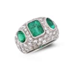 A domed emerald and diamond ring