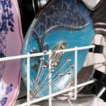 Sculpture with various china, ceramic, kitchen utensils and modified dishwasher on pedestal