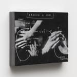 a small black and white panel with hands and writing on a white wall