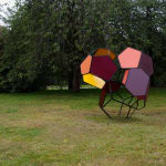 a large scale module sculpture in a green park