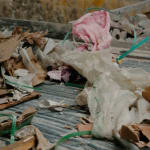 Karyn Olivier's Drift (Tributary), a video still of recyclables and debris on a conveyer belt