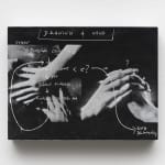 a small black and white panel with hands and writing on a white wall