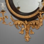 Regency carved giltwood and ebony convex mirror with griffin crest