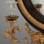 Regency carved giltwood and ebony convex mirror with griffin crest