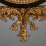 Regency carved giltwood and ebony convex mirror with griffin crest