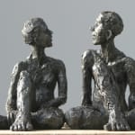 Seated male & female iron resin sculptures