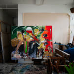 A colorful, semi-abstract, figural painting by artist Noah Jemison surrounded by other wrapped paintings in a loft setting