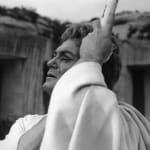 Black and white photograph of closeup of Jean Marais with bleeding eyes looking up to the left and holding a pole as Oedipus