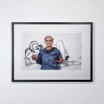 Framed Photograph of Tom Wesselmann holding a steel laser-cut drawing of an outline of a female nude