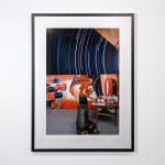 Framed Photograph of James Rosenquist working on a large red and blue painting next to a table with pots of paint