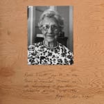 Photograph of an elderly woman mounted on wood with handwritten text below