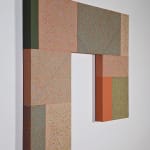 An eight-sided rectangular shape is divided into rectangular parcels of muted pink, blue, green, orange, and yellow acrylic