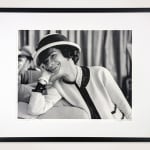 Framed black and white photograph of Designer Coco Chanel laughing on the couch