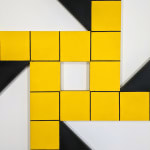 Close-up view of an acrylic painting on masonite of a shape formed by four identical black triangles with a strip of yellow surrounding one small square of negative space