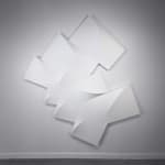 Large, white tridimensional painting composed of modules in a semicircle