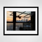 black framed photograph of the Manhattan skyline at sunset taken through an open window