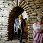 Woman walking underneath an archway made of sandbags