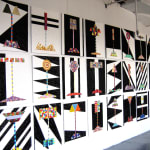 Array of geometric abstract paintings on a white wall