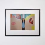Framed Photograph of Tom Wesselmann standing between two separated parts of a large painting of a female nude