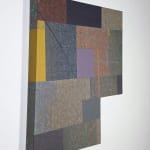 Six-sided shaped acrylic painting divided into rectangular parcels of muted yellows, greens, blues, and purples with a faint grid overlaid