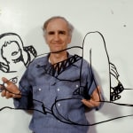 Photograph of Tom Wesselmann holding a steel laser-cut drawing of an outline of a female nude