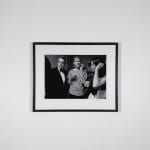 Framed Black and white photograph of three people, Andy Warhol, Marisol, and a man, holding cups at a party
