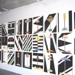 Array of geometric abstract paintings on a white wall