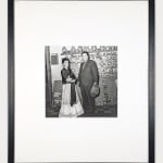Framed black and white photograph of Frida Kahlo and Diego Rivera posing in front of a tile-covered wall inside the Blue House