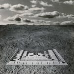 Framed black and white photomontage of an abstract structure in a baren landscape