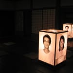 Four large illuminated lantern with lifelike photo portraits in a traditional Japanese tatami room