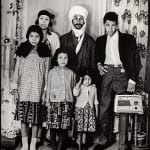 1960s black & white photograph of a family, mother, father and four children, in a photography studio