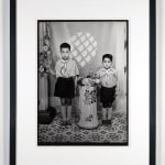 Framed 1960s black & white photograph of two children in school uniforms, in a photography studio