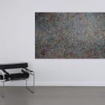 Abstract painting consisting of small marks covering the entire visual field hanging on a wall next to a chair