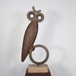 Modernist bronze sculpture of a stylized owl with large eyes perched on a circular base