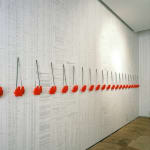 Art installation, wallpaper with mathematical data of atomic bomb explosions, red binoculars installed in a line on top