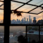 photograph of the Manhattan skyline at sunset taken through an open window