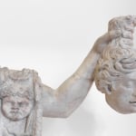 A detail of a pentelic marble sculpture depicting the mythological story of Perseus beheading Medusa.