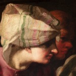 Detail of an oil painting of the Greek mythology story of Arachne. Two faces are looking in the same direction. In the foreground is a youthful woman in pink with a headscarf.