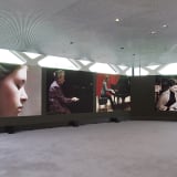 four screens with the work of Dara Birnbaum in Tokyo, at the Prada store in Aoyama; footage is of different girls playing the piano