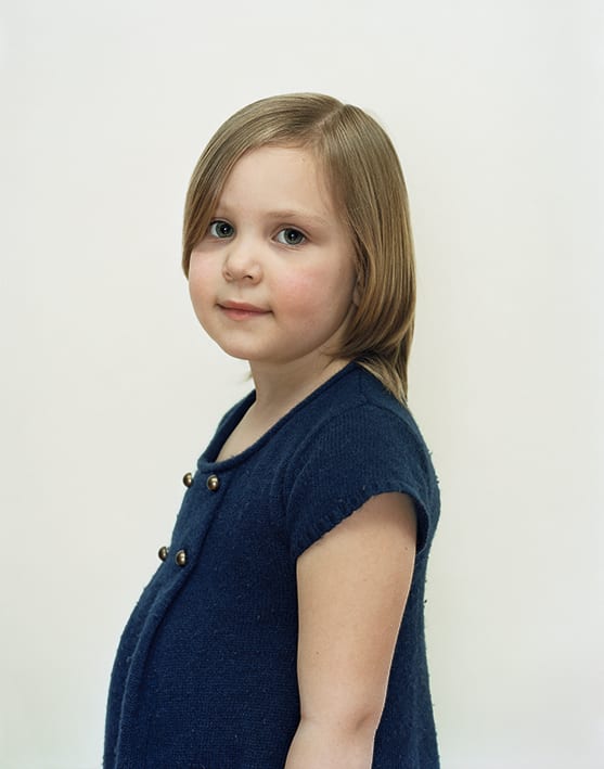 A Rineke Dijkstra portrait of a young girl in a blue shirt.