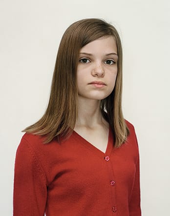 A Rineke Dijkstra portrait of a girl in a red shirt.