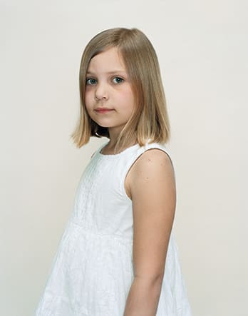 A Rineke Dijkstra portrait of a young girl in a white dress.