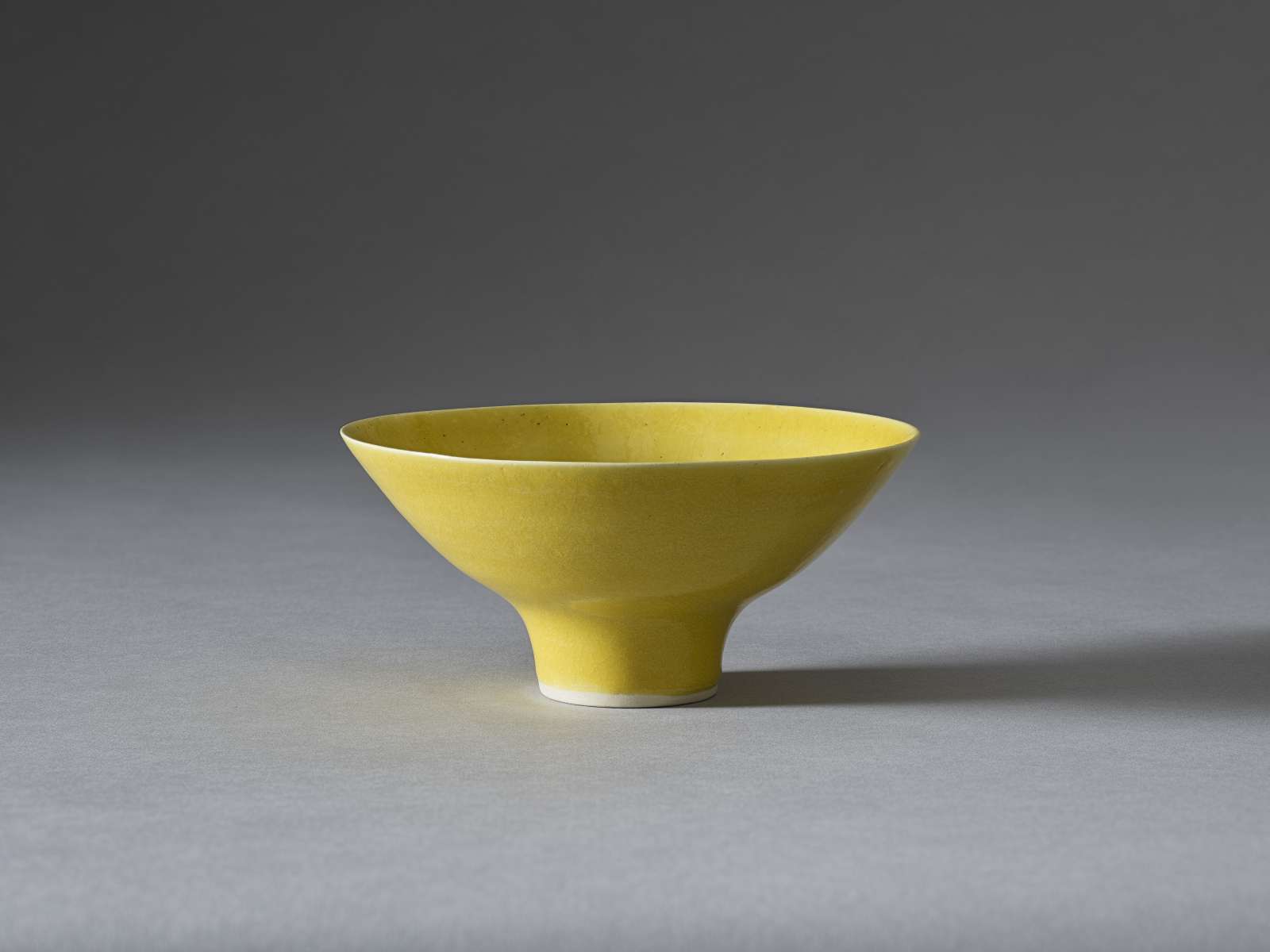 Lucie Rie, Yellow Footed Bowl, Impressed with artist’s seal, Porcelain with an all-over ‘American yellow’ glaze, height 8.5 cm, diameter 18 cm